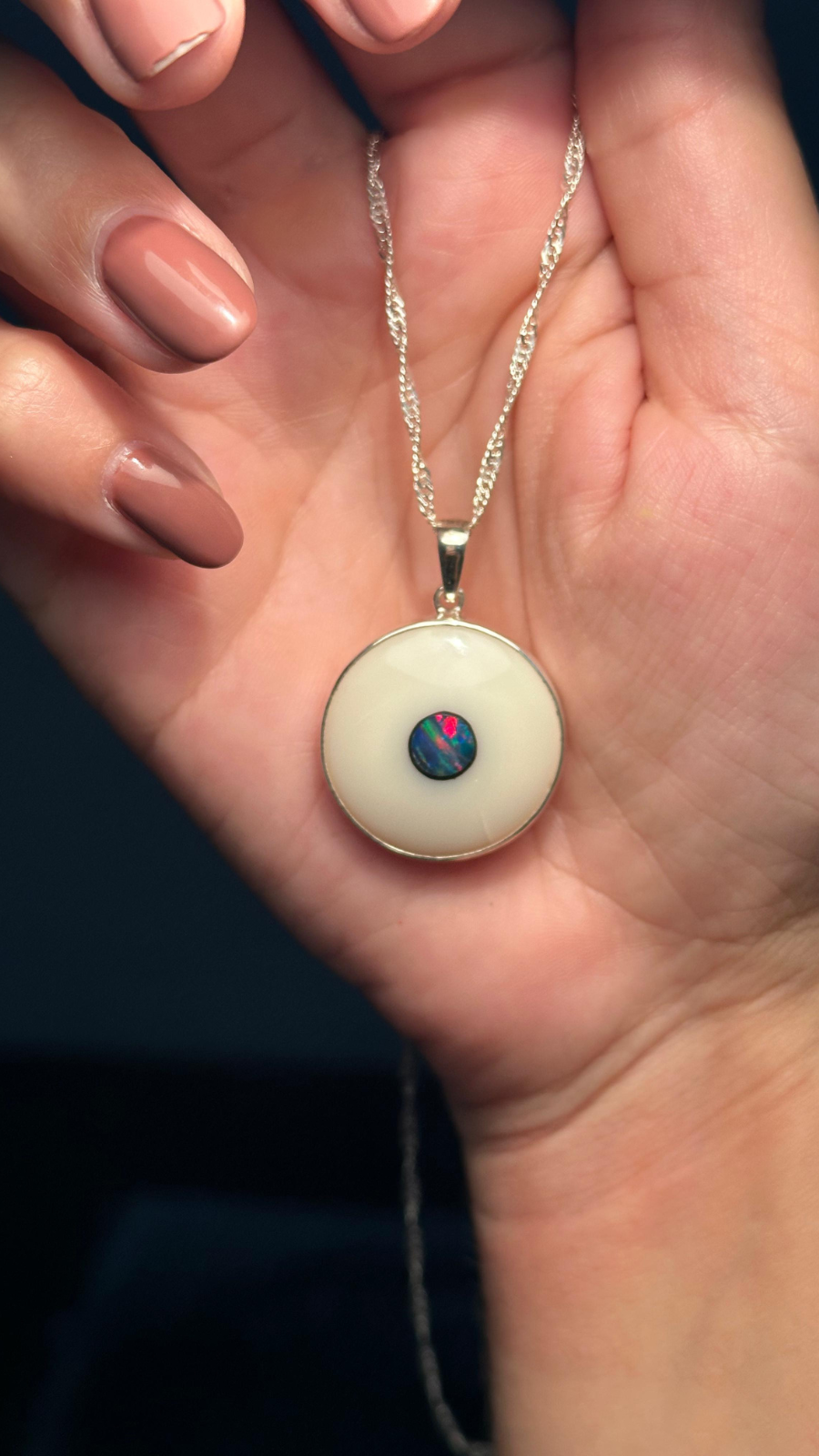 Opala Branca e Proteção: Pingente Olho Grego em Prata 950 – Elegância Mística Contra Energias Negativas Opala natural branca e prata pura se encontram neste pingente exclusivo de olho grego, unindo proteção espiritual, estilo refinado e energia positiva em uma só peça. A prata 950 garante durabilidade e brilho nobre, enquanto a opala branca – pedra conhecida por atrair luz e equilibrar emoções – amplia ainda mais o poder do símbolo ancestral contra o mau-olhado e as vibrações negativas. Este pingente não é apenas um acessório, é um verdadeiro amuleto moderno, que combina tradição e sofisticação para quem busca mais do que aparência: busca significado. Ideal para o dia a dia ou ocasiões especiais, ele se adapta ao seu estilo com leveza e elegância, sendo também uma excelente opção de presente com intenção e beleza. Carregue consigo proteção, espiritualidade e design atemporal em uma joia que fala por você.